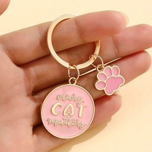 Detailed view of pink enamel cat paw keychain with 'Every Cat Matters' gold engraving