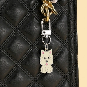 Détail du pendentif chien blanc sur sac en cuir noir matelassé avec fermoir argenté