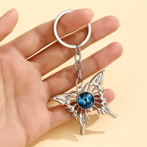Street style butterfly keychain with flame patterns and blue gemstone center