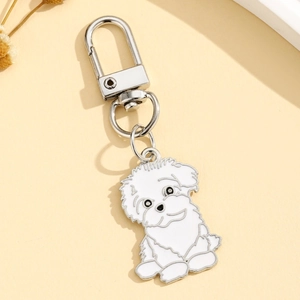 Détail d'un pendentif de chien en émail blanc avec un fermoir à ressort argenté en D