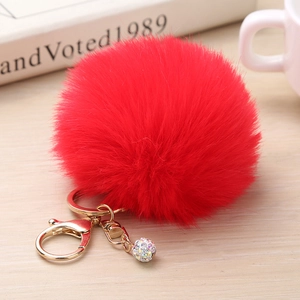Détail d'un porte-clés en fausse fourrure rouge avec fermoir doré et boule de strass