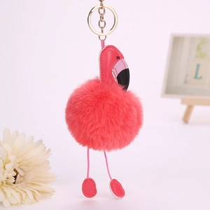 Porte-clés flamant rose en fausse fourrure avec anneau doré sur fond décoratif épuré