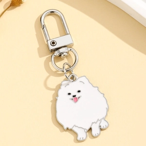 Porte-clés chien mignon en émail blanc avec crochet en argent sur fond jaune chaud