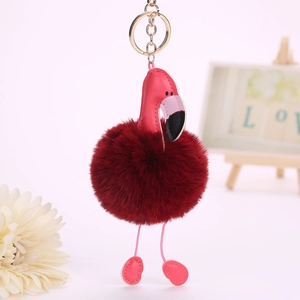 Détail d'un porte-clés flamant rose en cuir PU avec pompon bordeaux et anneau doré
