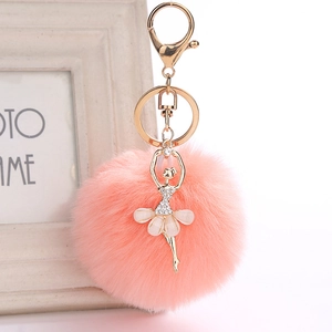 Close-up of pink faux fur pompom keychain with gold ballerina pendant and sparkling rhinestones