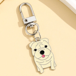Détail d'un porte-clés bouledogue blanc crème en émail avec fermoir mousqueton argenté