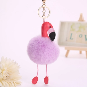Détail du porte-clés flamant rose avec pompon en fausse fourrure violette et cuir