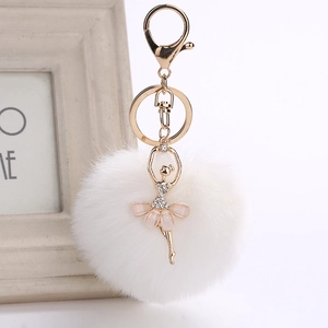 Detail of plush faux fur pompom keychain with crystal ballet dancer charm and lobster clasp