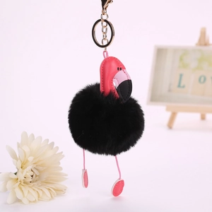 Détail du porte-clés flamant rose en similicuir avec pompon noir et mousqueton doré
