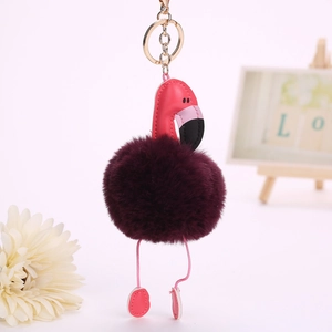 Détail de porte-clés flamant rose avec pompon en fausse fourrure et attache dorée