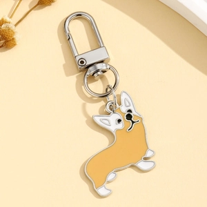 Détail du porte-clés corgi jaune avec fermoir en métal argenté sur fond minimaliste