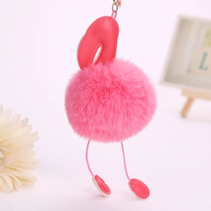 Détail du porte-clés flamant rose en peluche avec boule en fourrure et anneau doré
