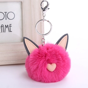 Detail of rose pink faux rabbit fur pompom keychain with grey cat ears and heart charm