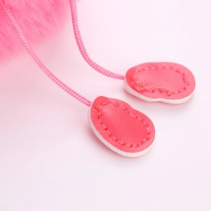 Détail d'un pendentif flamant rose en similicuir avec coutures blanches et fausse fourrure