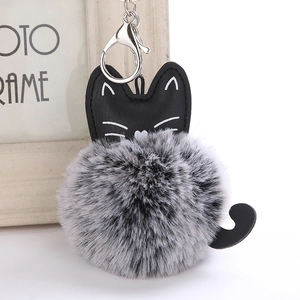 Detail of a cute PU leather cat keychain with a soft grey pompom and silver metal lobster clasp