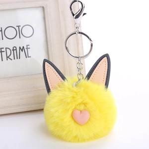 Detailed shot of yellow fluffy cat keychain with pink heart and silver metal lobster clasp