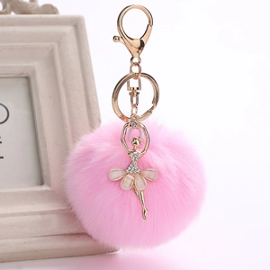 Detail view of pink fluffy faux fur ball keychain with a golden ballerina charm and crystal accents