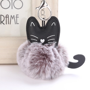 Detail of cute PU cat keychain featuring bicolor plush fur pompom and silver lobster clasp
