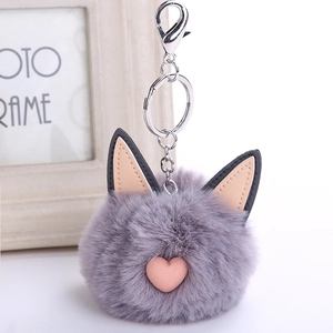 Close-up of grey fluffy faux fur cat ear keychain with pink heart and silver clasp