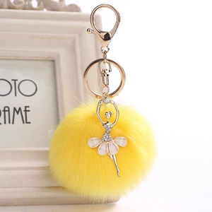 Detail of ballerina pendant with white pearlescent dress and yellow faux fur pompom charm