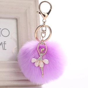 Detail of purple faux fur pompom keychain with a rhinestone ballet dancer pendant