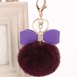 Faux rabbit fur keychain with a burgundy pompom and a purple rhinestone bow charm