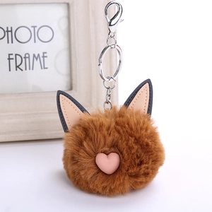 Close-up of brown faux fur fox keychain with pink heart nose and silver metal clasp