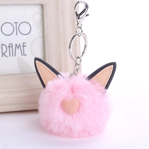 Detailed close-up of pink faux rabbit fur cat ear keychain with soft heart and silver clasp