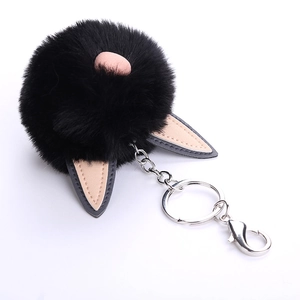 Detailed macro view of black faux fur ball keychain with pink PU leather ears and silver clip