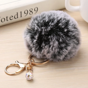 Détail d'un porte-clés en fausse fourrure avec pompon dégradé et boule de cristal brillant