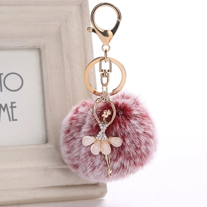 Detail of ballerina keychain with rhinestone corset, petal skirt and plush faux fur pompom