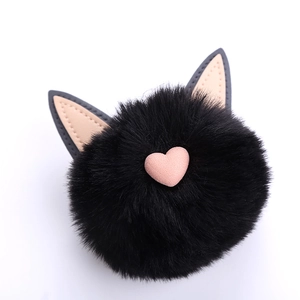Close-up of black faux fur cat ear bag charm with a pink heart decoration and soft texture