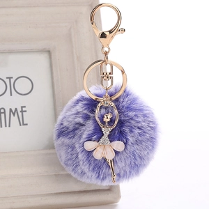 Detail of purple faux fur ball keychain with rhinestone ballet dancer pendant in gold