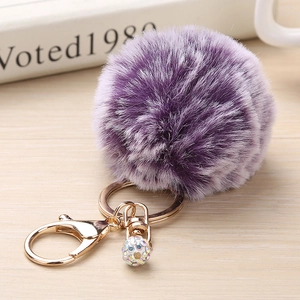 Détail du porte-clés en fausse fourrure violette avec fermoir doré et boule de strass brillant