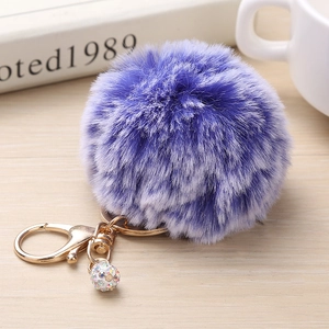 Détail du porte-clés pompon en fausse fourrure violette avec fermoir doré et strass