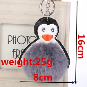 Detalle del llavero pompón de pingüino que muestra altura de 16cm y diámetro de 8cm