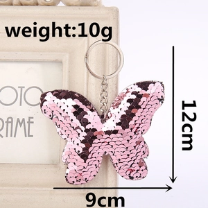 Pink and purple sequin butterfly keychain pendant with metallic ring and chain on photo frame