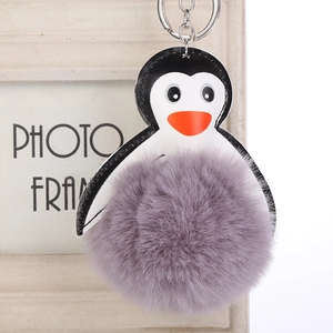 Llavero de pingüino de cuero sintético con un gran pompón de piel sintética en color lila
