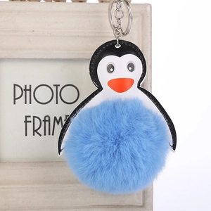 Detalle de llavero de pingüino de peluche azul con pompón y anillo de metal plateado