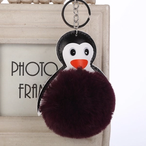 Detalle de llavero de pingüino con pompón de piel sintética morada y clip de metal duradero