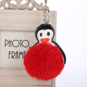 Detalle de llavero de pingüino con pompón rojo de pelo sintético y cabeza de cuero
