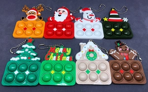 Dettaglio di 8 portachiavi antistress natalizi in silicone con campanelli e alberi
