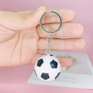 Detailed view of an acrylic classic soccer ball keychain held in hand for scale