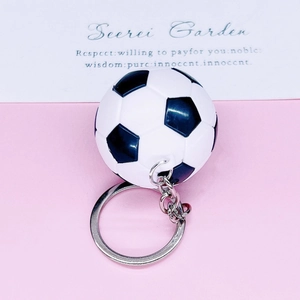 Close-up of classic black and white 3D soccer keychain with silver metal ring and chain