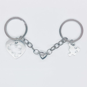 Detail of silver couple map puzzle keychain with magnetic heart and polished alloy finish