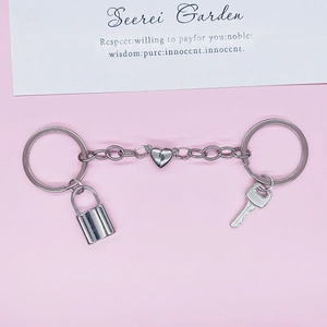 Magnetic silver heart lock and key couple keychain set on a pink background for lovers