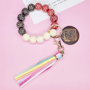 Portachiavi con perline leopardate, ciondolo MAMA e nappa arcobaleno su sfondo rosa