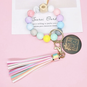 Bracelet en perles de silicone colorées avec pendentif MAMA et pompon en cuir rayé