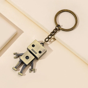 Vintage bronze alloy robot keychain with movable limbs on a minimalist background