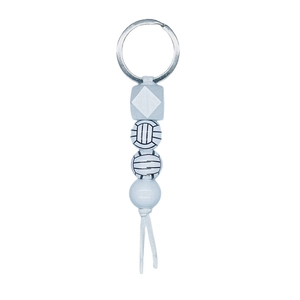 Detailed macro view of volleyball printed beads and a silver metal ring on keychain